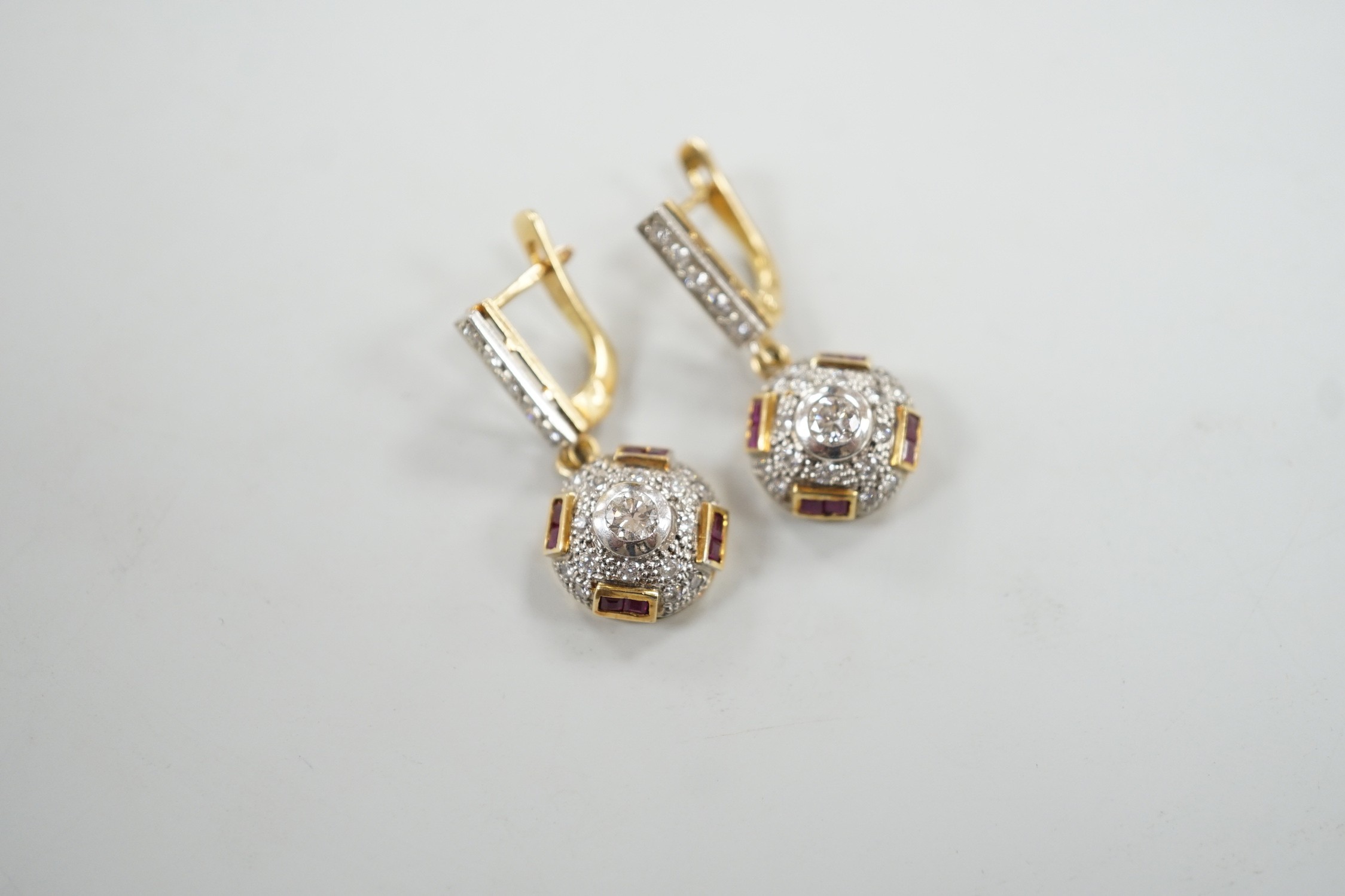 A modern pair of yellow metal, square cut ruby and round cut diamond set circular cluster drop earrings, 30mm, gross weight 8.4 grams.
